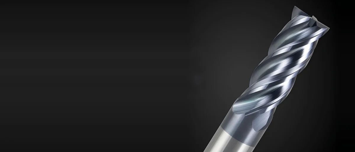 Gray-blue coated 4-flute solid carbide end mill, close-up of the cutting end on a dark background