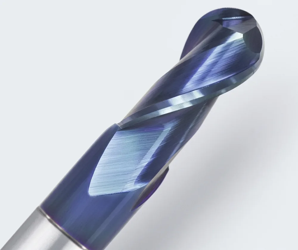 Solid carbide ball nose end mill with a blue-violet coating, close-up of the ball end and helical flutes