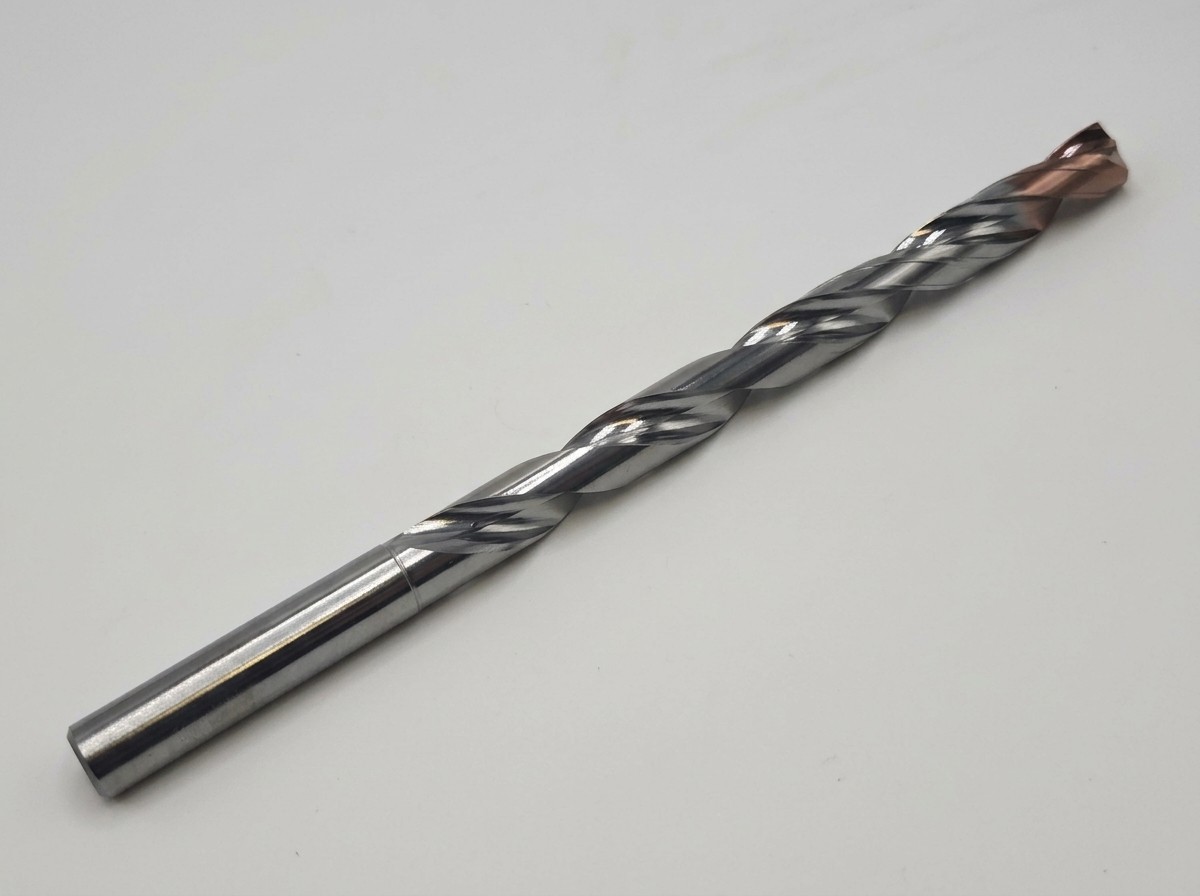 Solid carbide drill photographed in full, with a coated point, helical flutes, and a cylindrical shank.